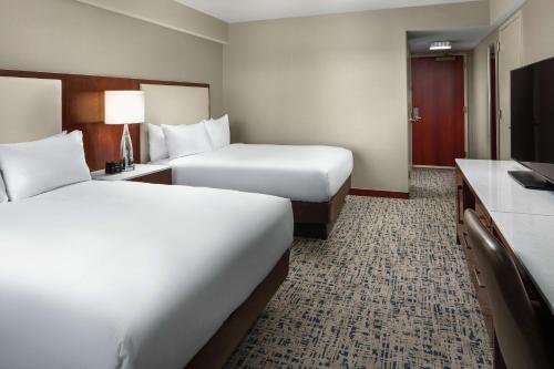 a hotel room with two beds and a television at Hilton Boston Logan Airport in Boston