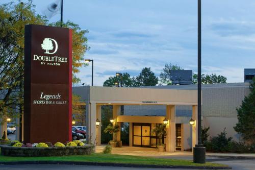 a sign in front of a building with a sign at DoubleTree by Hilton Boston-Milford in Milford