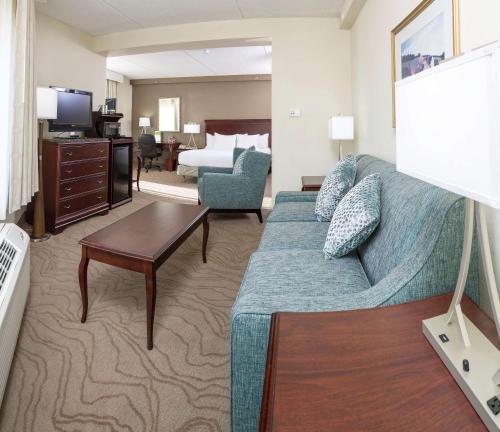 a living room with a couch and a bed at DoubleTree by Hilton Boston-Milford in Milford