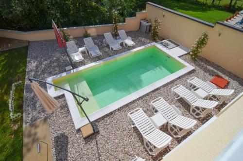 uma vista sobre uma piscina com espreguiçadeiras e uma piscina em Planinska Oaza em Pale