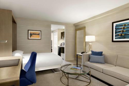 a hotel room with a bed and a couch and a table at DoubleTree Suites by Hilton Hotel Boston - Cambridge in Boston