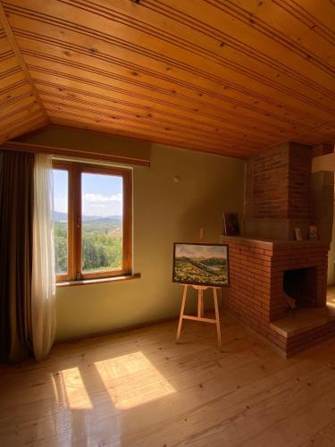 a room with a fireplace and a large window at Art Racha in Ambrolauri