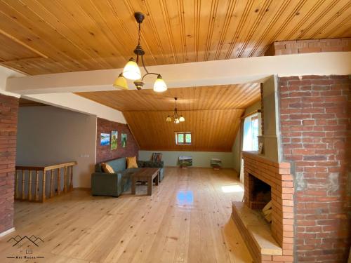 a living room with a fireplace and a brick wall at Art Racha in Ambrolauri