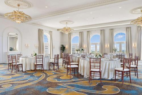 a banquet room with tables and chairs and chandeliers at Hilton Baton Rouge Capitol Center in Baton Rouge