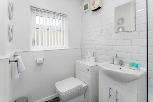 a white bathroom with a toilet and a sink at Woodbine House - Air Host and Stay - Free parking - Contractor Friendly in Liverpool