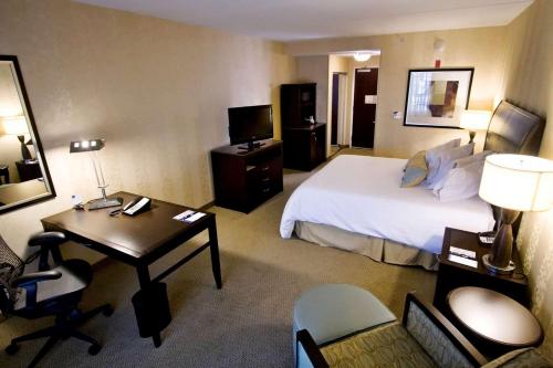 a hotel room with a bed and a desk and a room at Hilton Garden Inn Aberdeen in Aberdeen