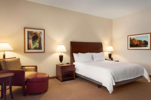 Habitación de hotel con cama y silla en Hilton Garden Inn Bartlesville en Bartlesville