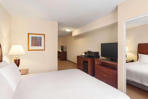 a hotel room with a bed and a flat screen tv at Hilton Garden Inn Bartlesville in Bartlesville