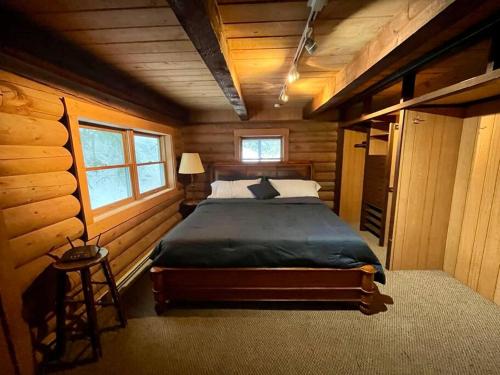 1 dormitorio con 1 cama en una cabaña de madera en 3-Level Log Cabin near Silverwood - Tranquil, en Spirit Lake