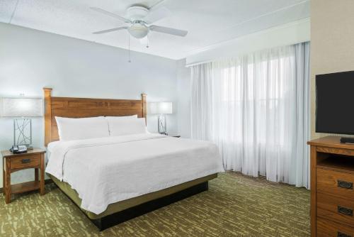 een slaapkamer met een bed en een flatscreen-tv bij Homewood Suites by Hilton Buffalo-Amherst in Amherst