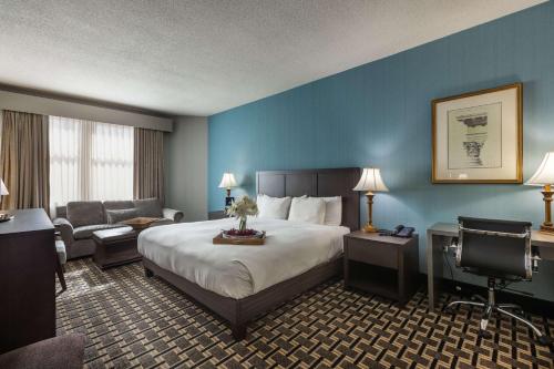 ボルチモアにあるInn at the Colonnade Baltimore - A DoubleTree by Hilton Hotelの大きなベッドとデスクが備わるホテルルームです。
