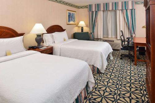 a hotel room with two beds and a desk at Hilton Garden Inn Columbia in Columbia