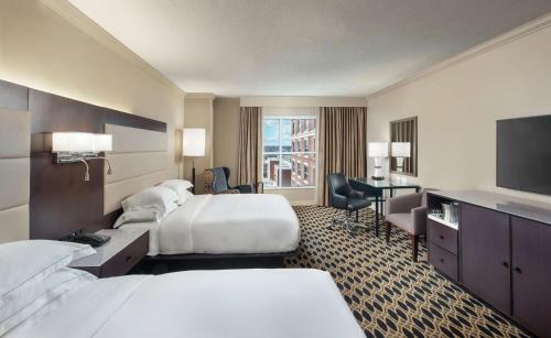 a hotel room with two beds and a television at Hilton Columbia Center in Columbia