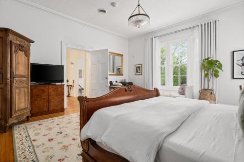a bedroom with a bed and a flat screen tv at The CAPE in Picton