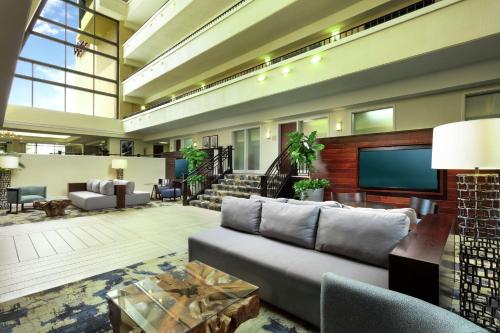 a living room with a couch and a tv at DoubleTree by Hilton Hotel Columbia in Columbia