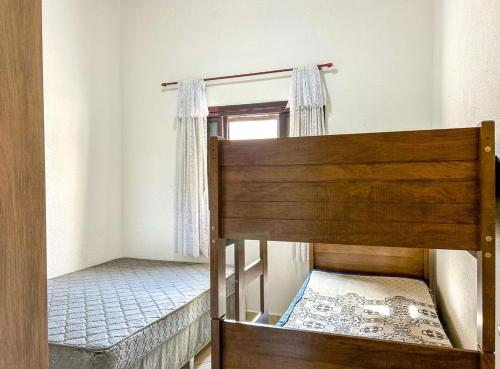 two bunk beds in a room with a window at Otima casa com WiFi e churrasqueira em Bertioga SP in Boracéia