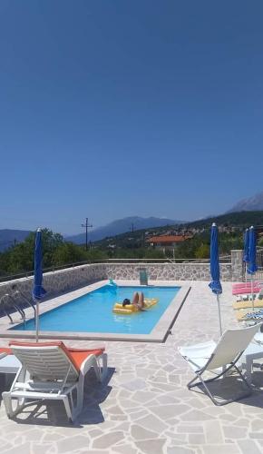 a person laying on a raft in a swimming pool at Vila Rogač in Tivat