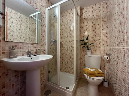 een badkamer met een wastafel, een douche en een toilet bij Tropical chic in Casares