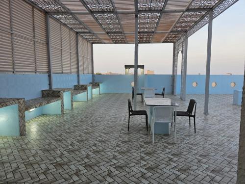 a room with tables and chairs on a roof at Al Saad chalet in Al Ashkharah