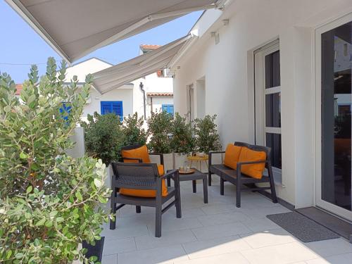 a patio with chairs and a table on a porch at Sikelia Superior Rooms Milazzo in Milazzo
