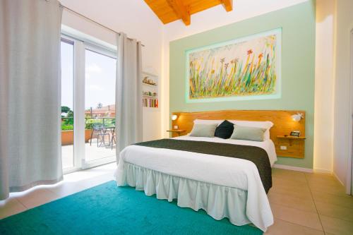 1 dormitorio con cama y ventana grande en Le Monachelle Luxury, en Éboli