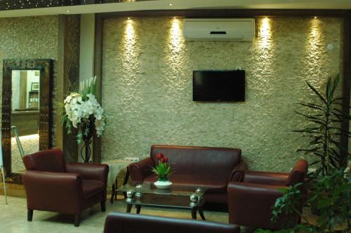 a waiting room with chairs and a tv on a wall at Konak Saray Hotel in İzmir