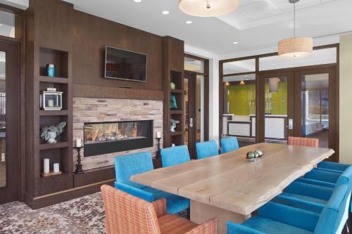 a dining room with a table and chairs and a fireplace at Hilton Garden Inn Akron in Akron