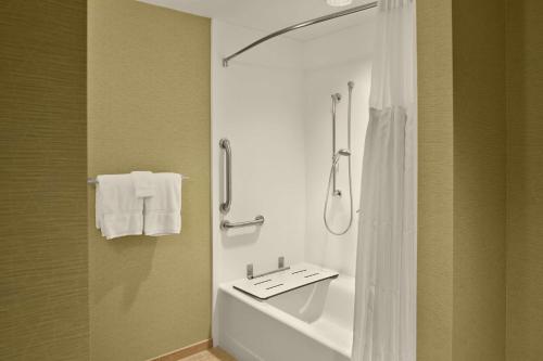 La salle de bains est pourvue d'un lavabo blanc et d'une douche. dans l'établissement Hilton Garden Inn Akron, à Akron