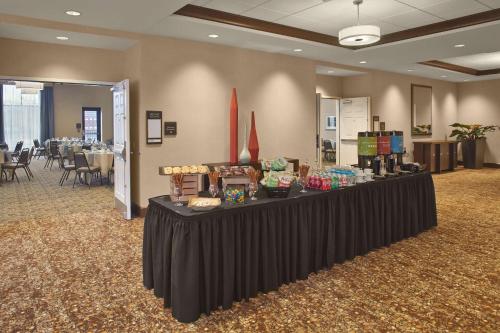 a black table in a room with tables and chairs at Hilton Garden Inn Akron in Akron