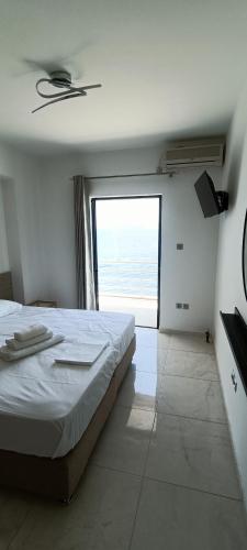 ein Schlafzimmer mit einem großen Bett und einem großen Fenster in der Unterkunft Christinas 1 in Nerántza