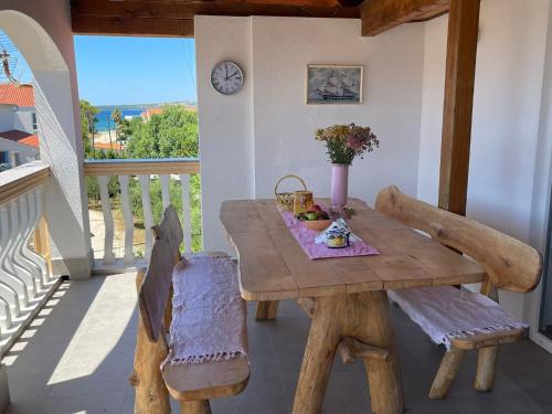 d'une table et de chaises en bois sur un balcon. dans l'établissement Joyful apartments with beautiful view, à Privlaka