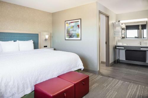 a hotel room with a large bed and a sink at Hampton Inn Freeport in Freeport