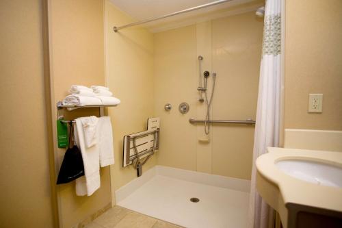 uma casa de banho com um chuveiro e um lavatório. em Hampton Inn Freeport em Freeport