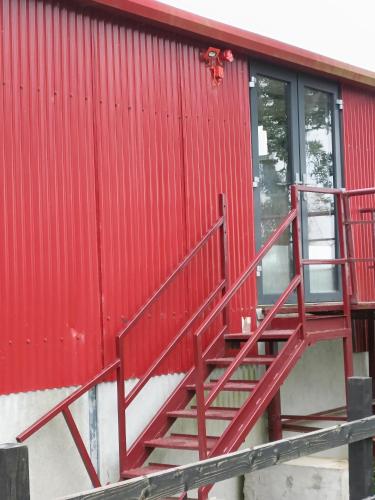 a red staircase on the side of a red building at Shed Loft apartment in Longford