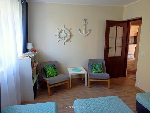 Una sala de estar con dos sillas y una mesa. en Dom JAMAR - apartamenty, en Jastrzębia Góra