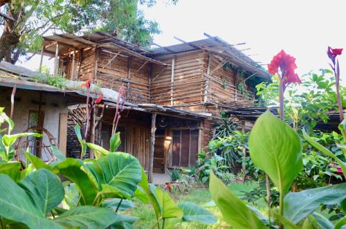an old wooden house in the middle of a garden at Mountain Bikes House in Moshi