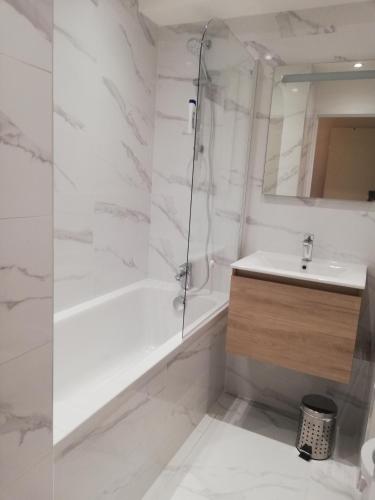 une salle de bain blanche avec une douche et un lavabo dans l'établissement Studio Olympe, à Juan-les-Pins