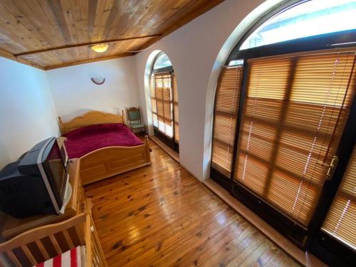 1 dormitorio con 1 cama y TV. en Семейный комплекс для отдыха en Pečurice