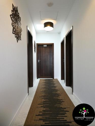a hallway with a door and a rug on the floor at Seliga Sport Apartments & SPA in Lesznowola