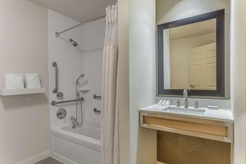 ein Bad mit einem Waschbecken und einer Dusche mit einem Spiegel in der Unterkunft Hilton Garden Inn Saint Charles in Saint Charles