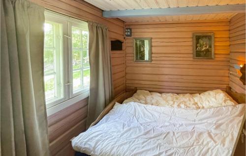 a bedroom with a bed in a wooden wall at Nice Home In bogen With House Sea View in Kongsvinger