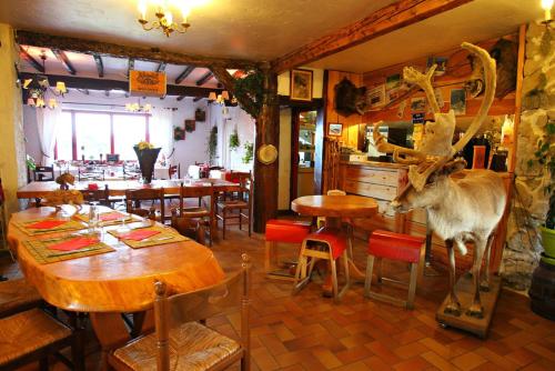 a deer statue in a restaurant with tables and chairs at La Godille in Andon