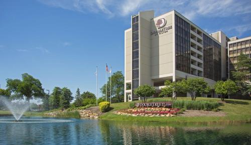 a rendering of a hotel with a fountain in a pond at DoubleTree by Hilton Chicago - Oak Brook in Oak Brook