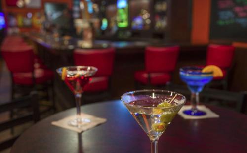 three wine glasses sitting on a table in a bar at DoubleTree by Hilton Chicago - Oak Brook in Oak Brook