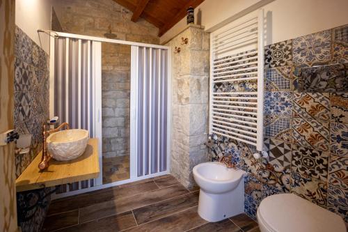 a bathroom with a toilet and a sink and a window at Casale Della Contea in Modica