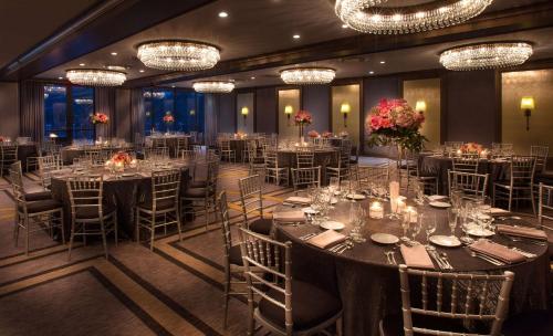 a banquet hall with tables and chairs and chandeliers at DoubleTree by Hilton Chicago - Oak Brook in Oak Brook