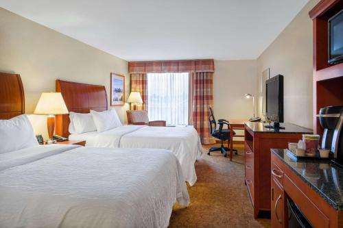 Habitación de hotel con 2 camas, escritorio y TV. en Hilton Garden Inn Cleveland East / Mayfield Village, en Mayfield