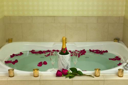 a bath tub with a bottle of champagne and two wine glasses at Hilton Garden Inn Cleveland East / Mayfield Village in Mayfield