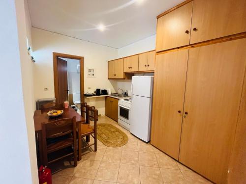 a kitchen with a table and a white refrigerator at Ammoudeli Apartments in Plomari