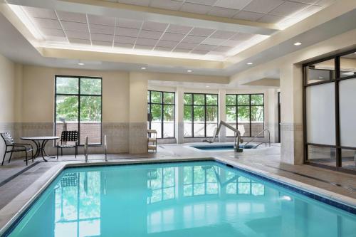 a pool in a hotel lobby with a table and chairs at Hilton Garden Inn Charlotte/Ayrsley in Charlotte